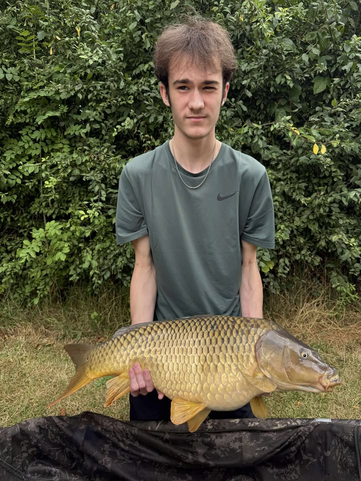 Young angler holding his first carp at Alderwood Fishery